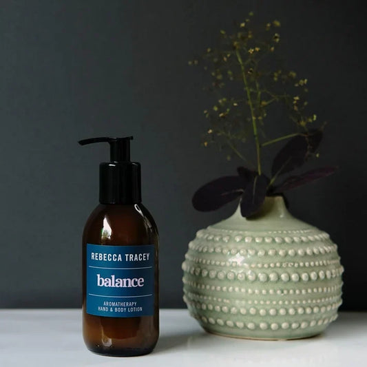 a pump bottle with rebecca tracey balance written on it and a plant