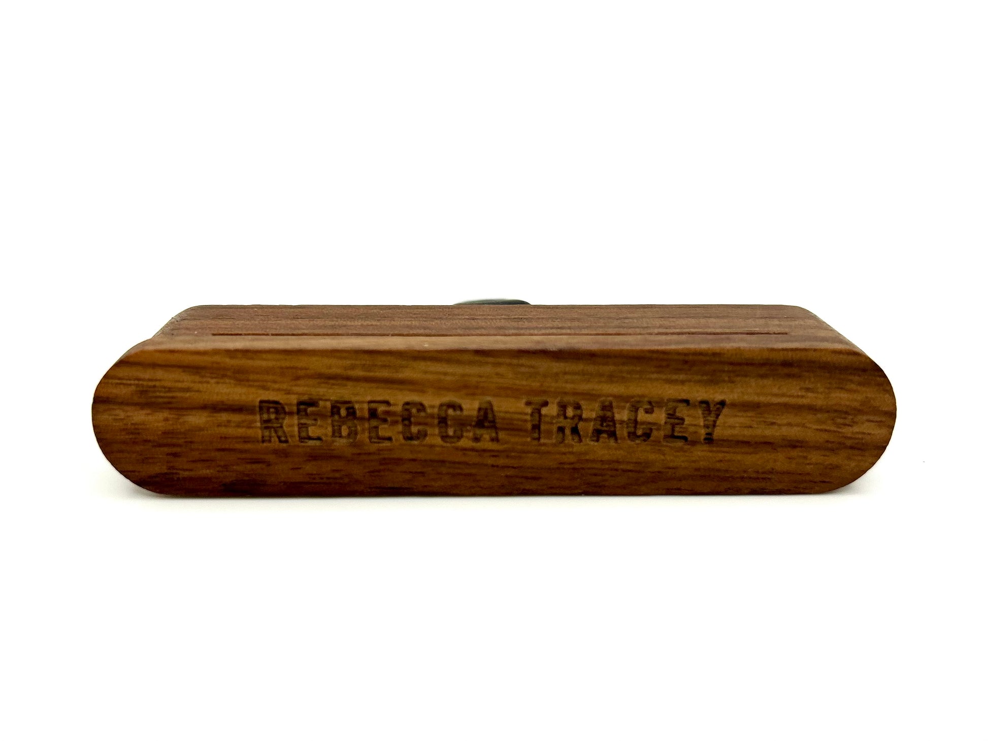 A personalized wooden box with rounded ends, featuring the engraved name 'REBECCA TRACEY' on the front, shown against a plain white background.