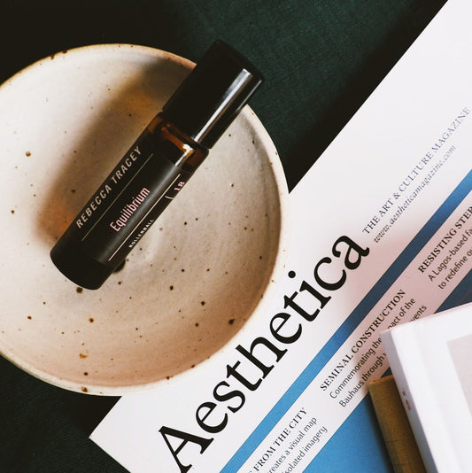 Equilibrium roller ball on ceramic dish and magazine behind