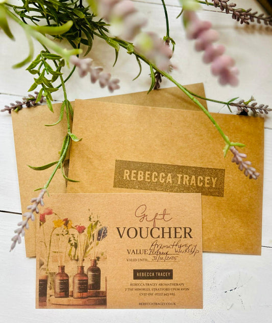 Gift voucher with 'Rebecca Tracey' branding on a wooden surface with lavender branches.