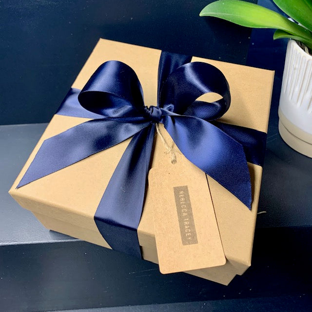 kraft luxury box gift wrapped with royal blue ribbon