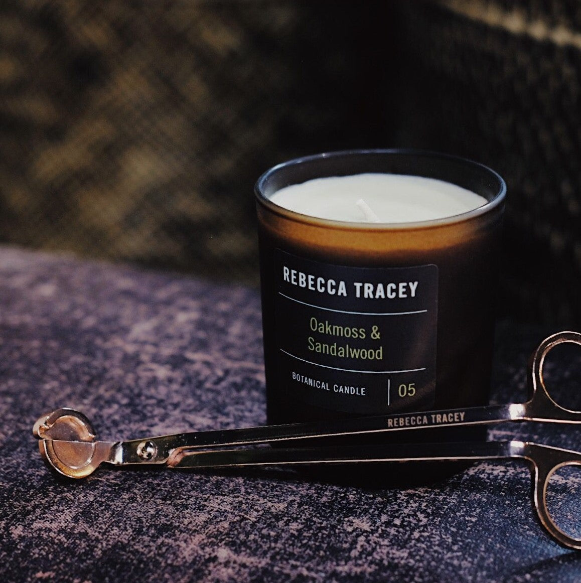candle on velvet and wick trimmers in front