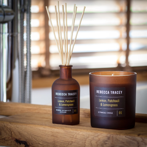 Rebecca Tracey candle and diffuser set on a wooden surface with a blurred background