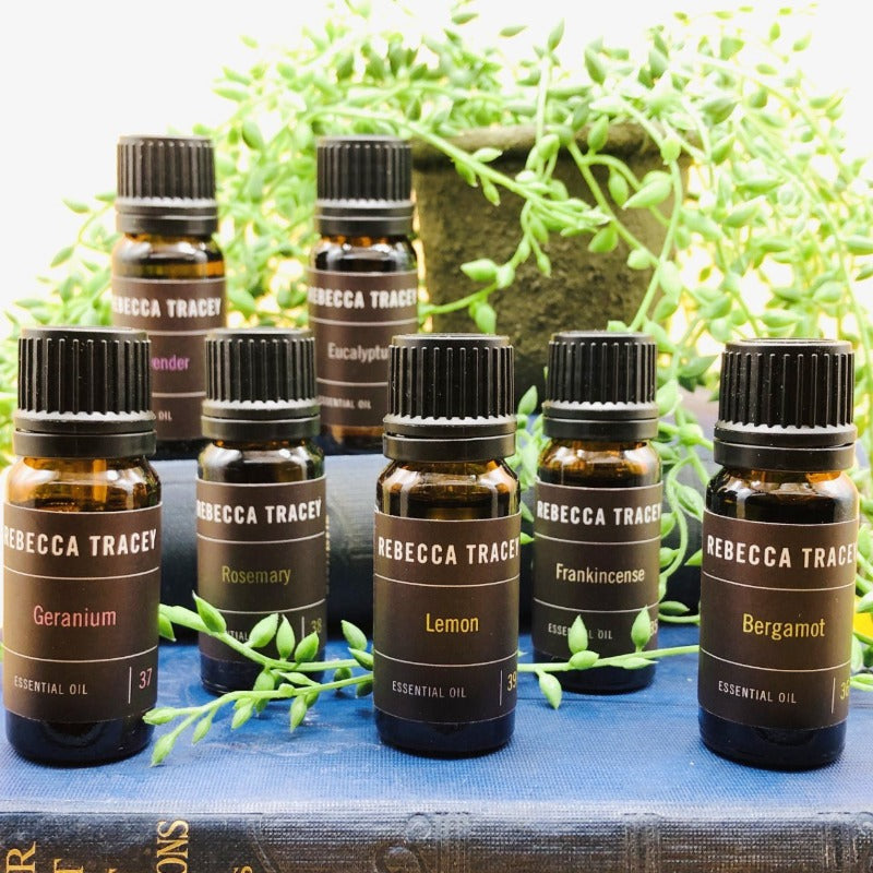 essential oils on blue book with greenery